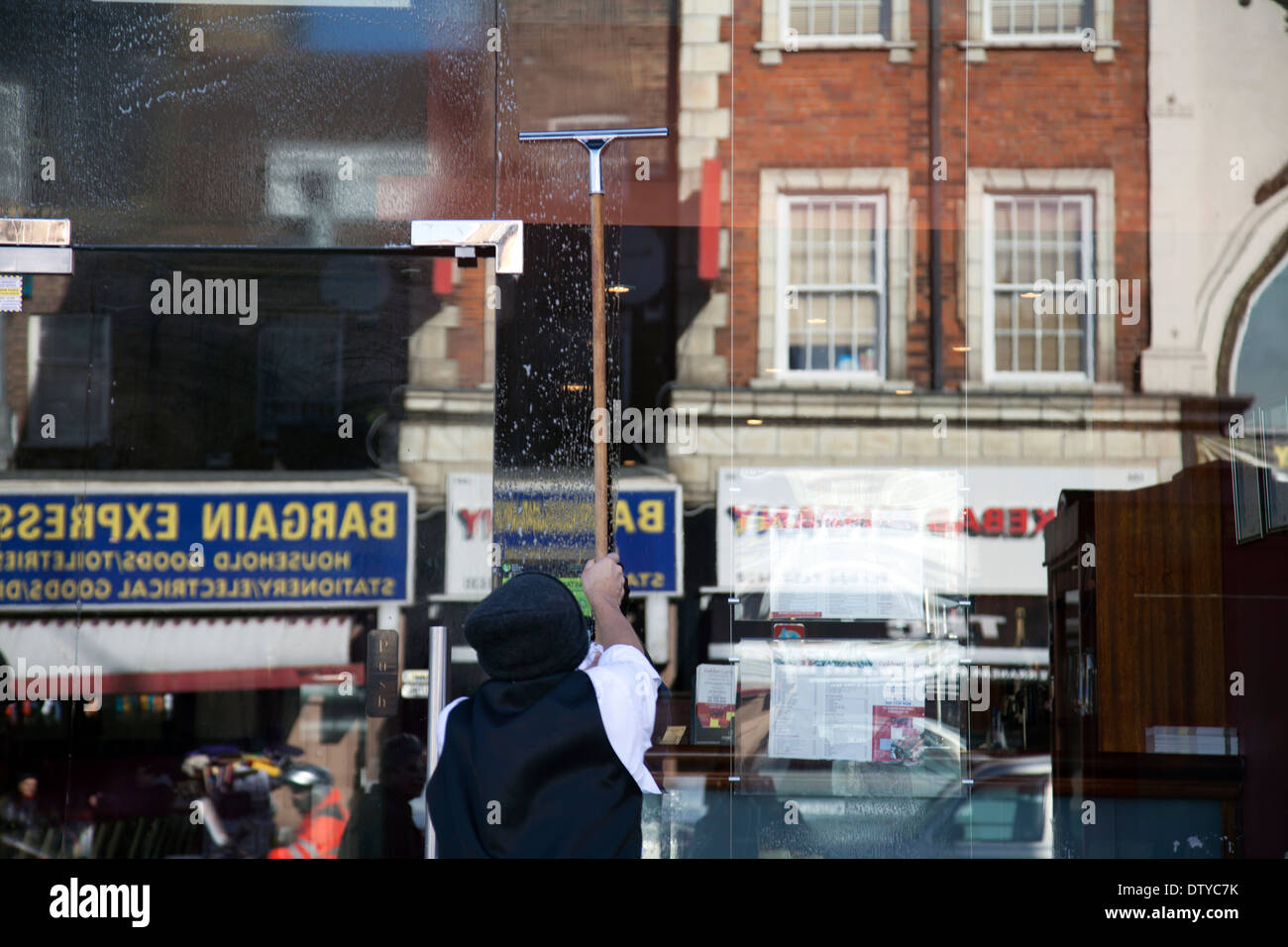 Man Washing Windows to Indian Restaurant in Clapham - London UK Stock Photo