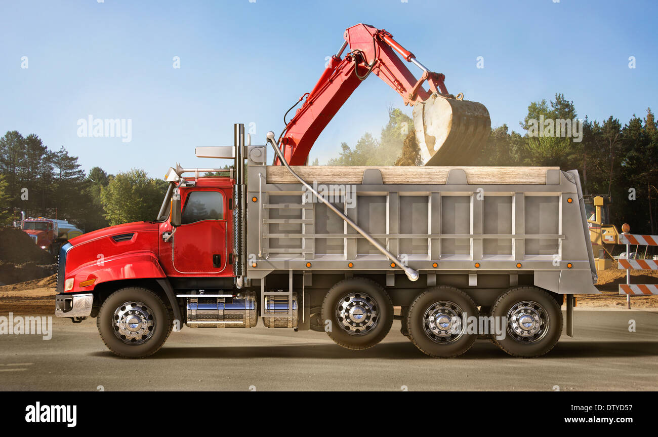 Digger scooping into dump truck on site Stock Photo