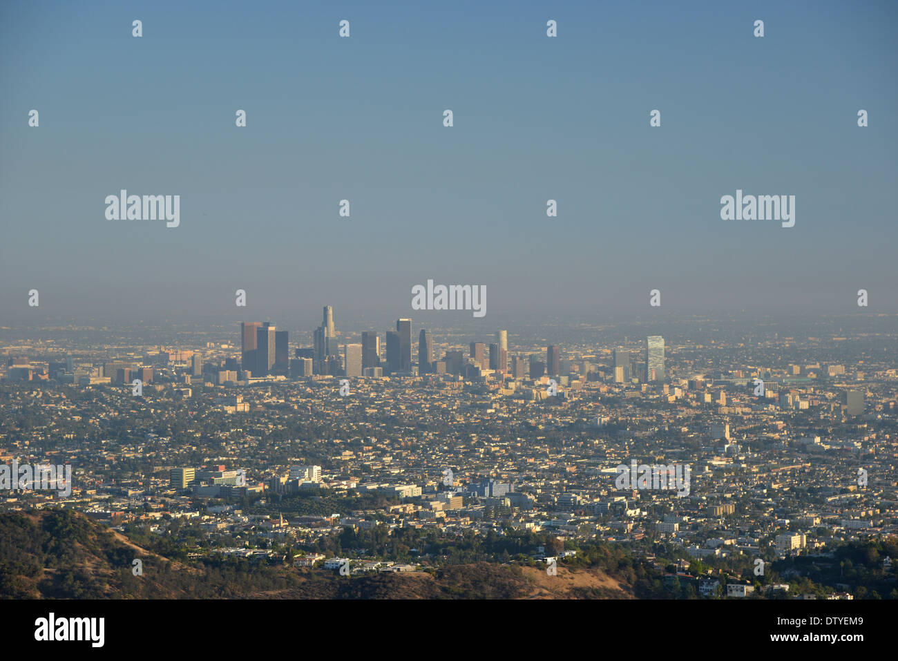 Downtown LA and its smog beneath a blue sky and heat shimmer seen from the Hollywood hills Stock Photo