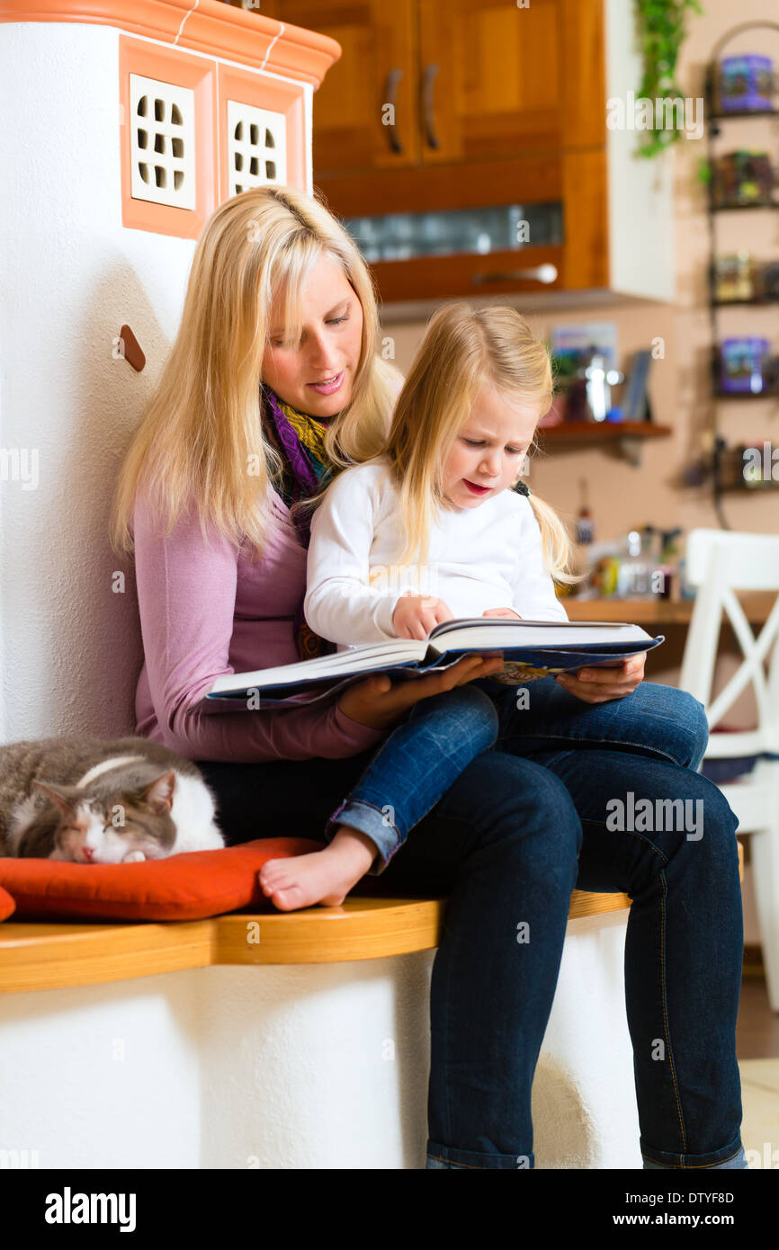 Mother reading tired daughter good night story out of storytelling book Stock Photo