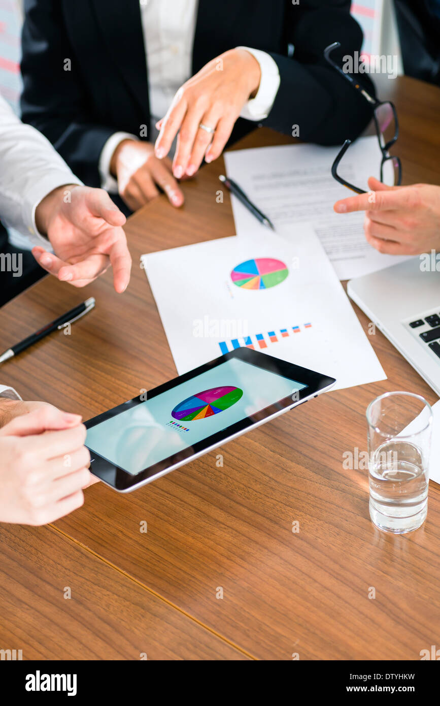 Business - banker, Manager or expert in meeting evaluates the figures on tablet computer Stock Photo