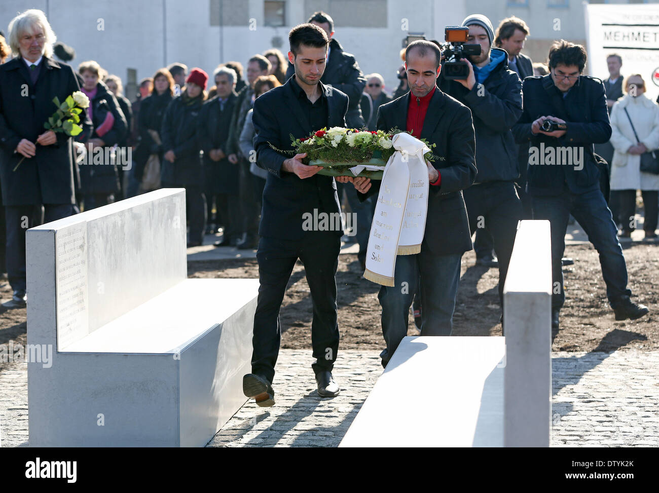 Rostock, Germany. 25th Feb, 2014. Brothers of murder victim Mehmet Turgut, Mustafa (L) and Yunus Turgut, lay a wreath at the memorial for Mehmet Turgut, a presumed victim of far-right German terrorist group National Socialist Underground (NSU) in Rostock, Germany, 25 February 2014. Exactly ten years after owner of a Turkish take-away, Turgut, was murdered, Rostock has unveiled a memorial. Photo: AXEL HEIMKEN/DPA/Alamy Live News Stock Photo