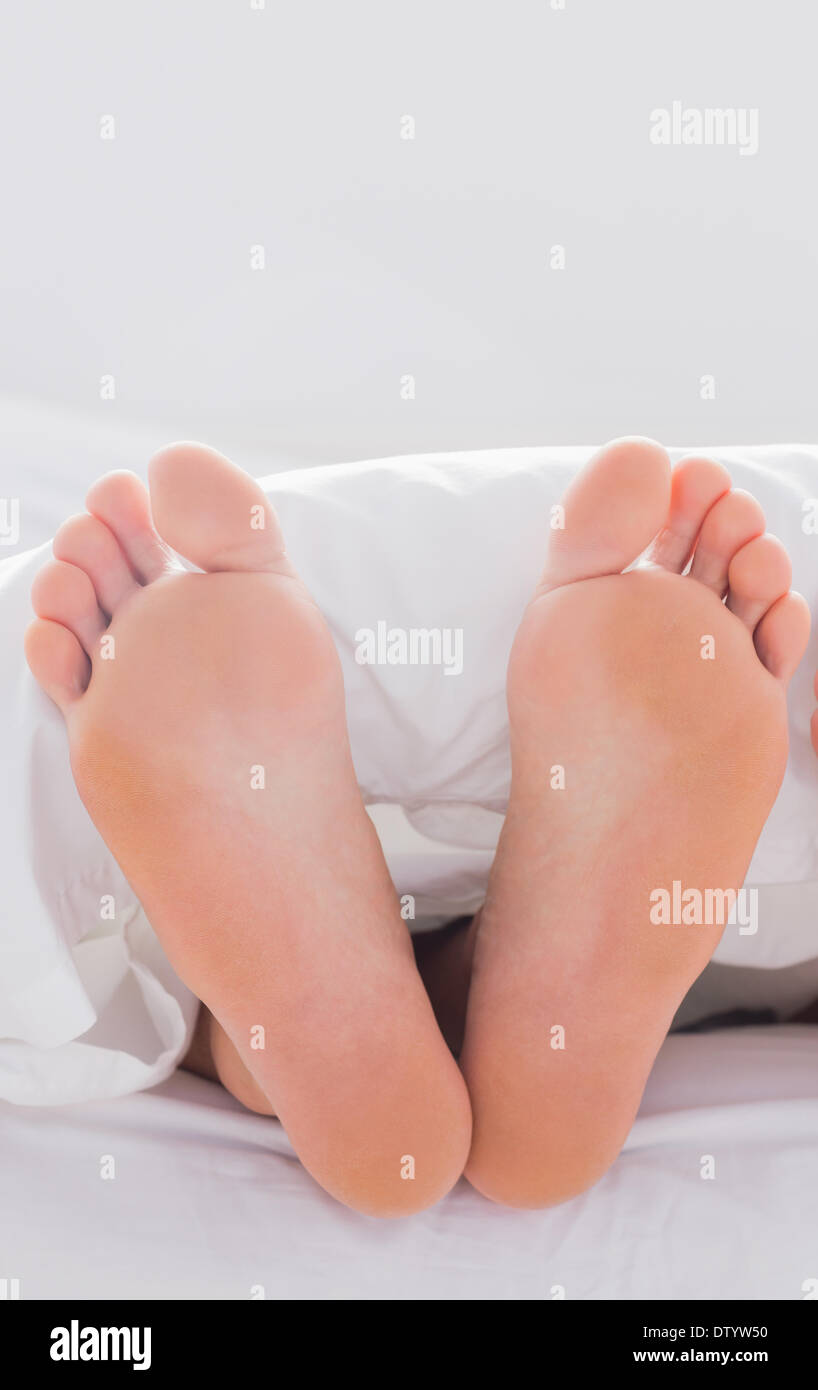 Feet sticking out from the quilt Stock Photo Alamy