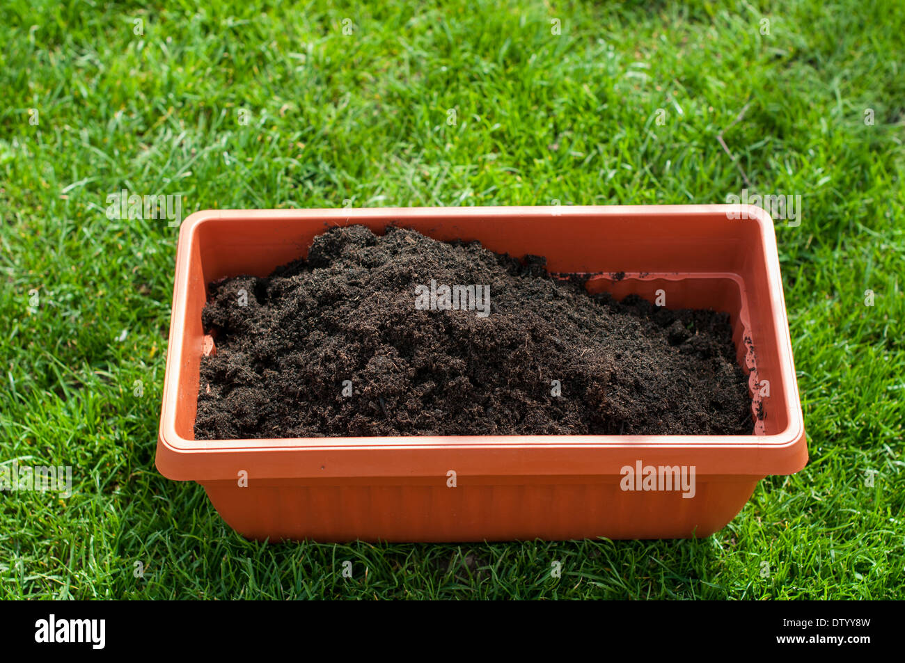 Pot with compost on a green grass Stock Photo Alamy