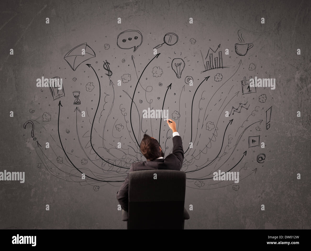 Businessman in front of a chalkboard deciding with arrows and signs Stock Photo
