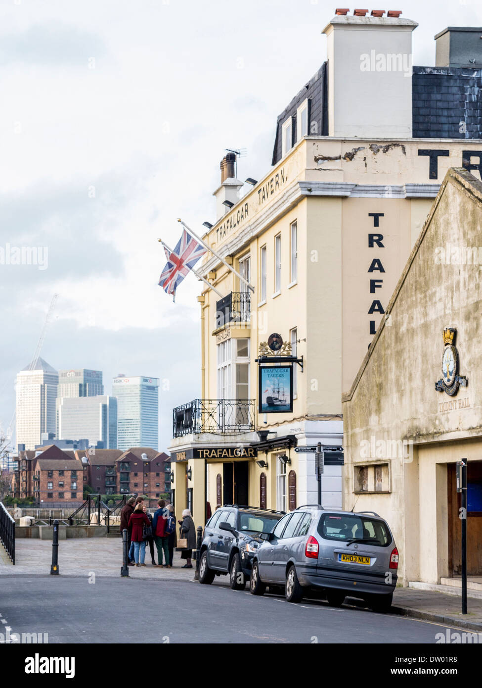 Trafalgar Tavern pub, Trident Hall stone building in Greenwich with Canary Wharf Financial Centre in the distance, London, UK Stock Photo