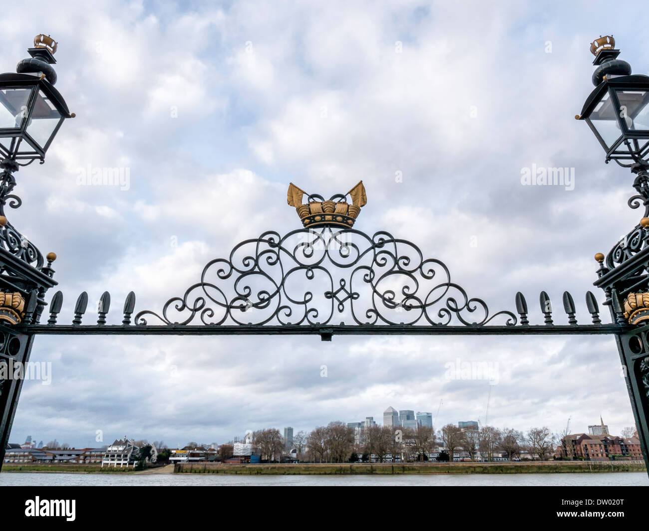 View of Canary Wharf financial district and Tower Hamlets apartment housing through ornate metal gate at Greenwich, London, UK Stock Photo