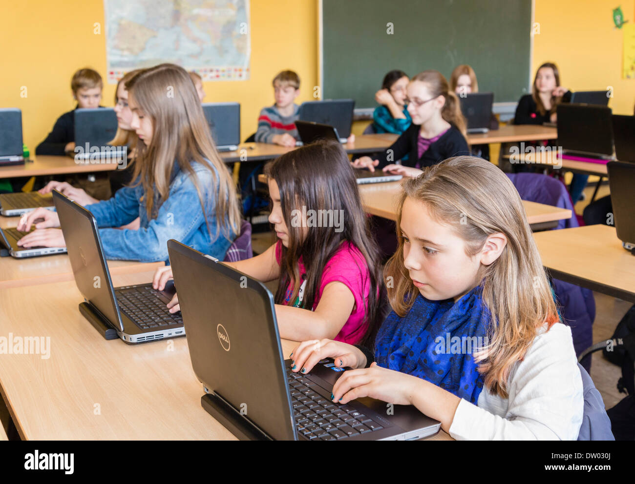 Junior high school students (about 12 years old) work with their laptops in their classroom. Stock Photo