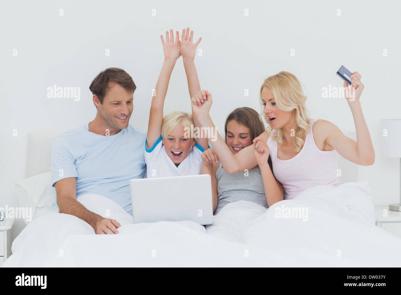 Family using a laptop in bed Stock Photo