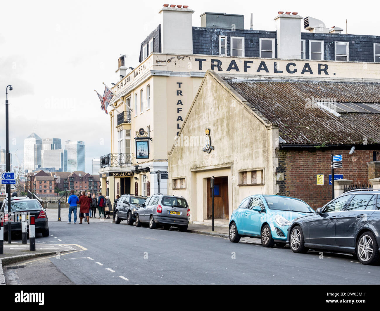 Trafalgar tavern pub, Trident hall stone building in Greenwich with Canary Wharf Financial Centre in the distance, London, UK Stock Photo