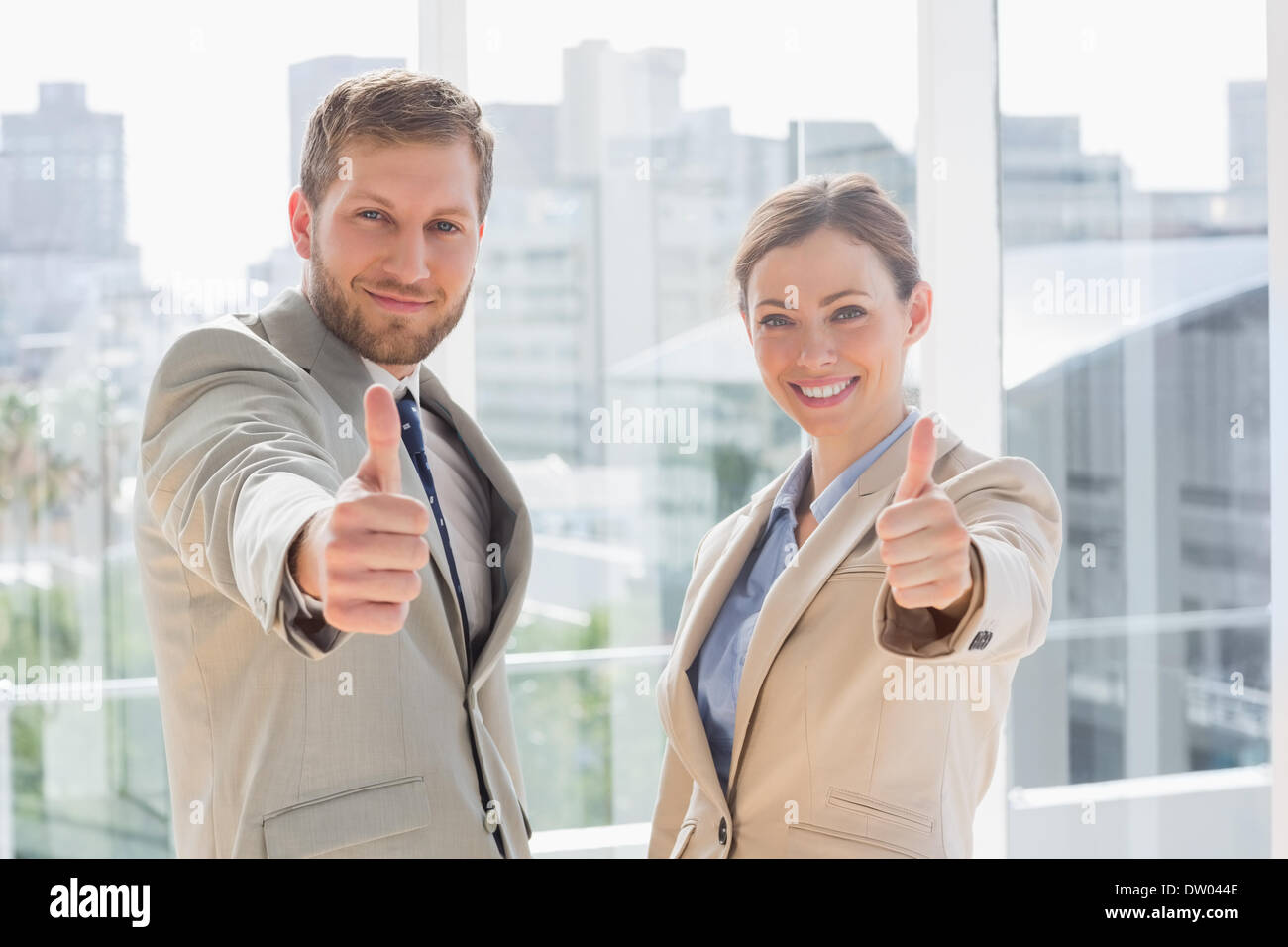 Smiling business team giving thumbs up Stock Photo - Alamy