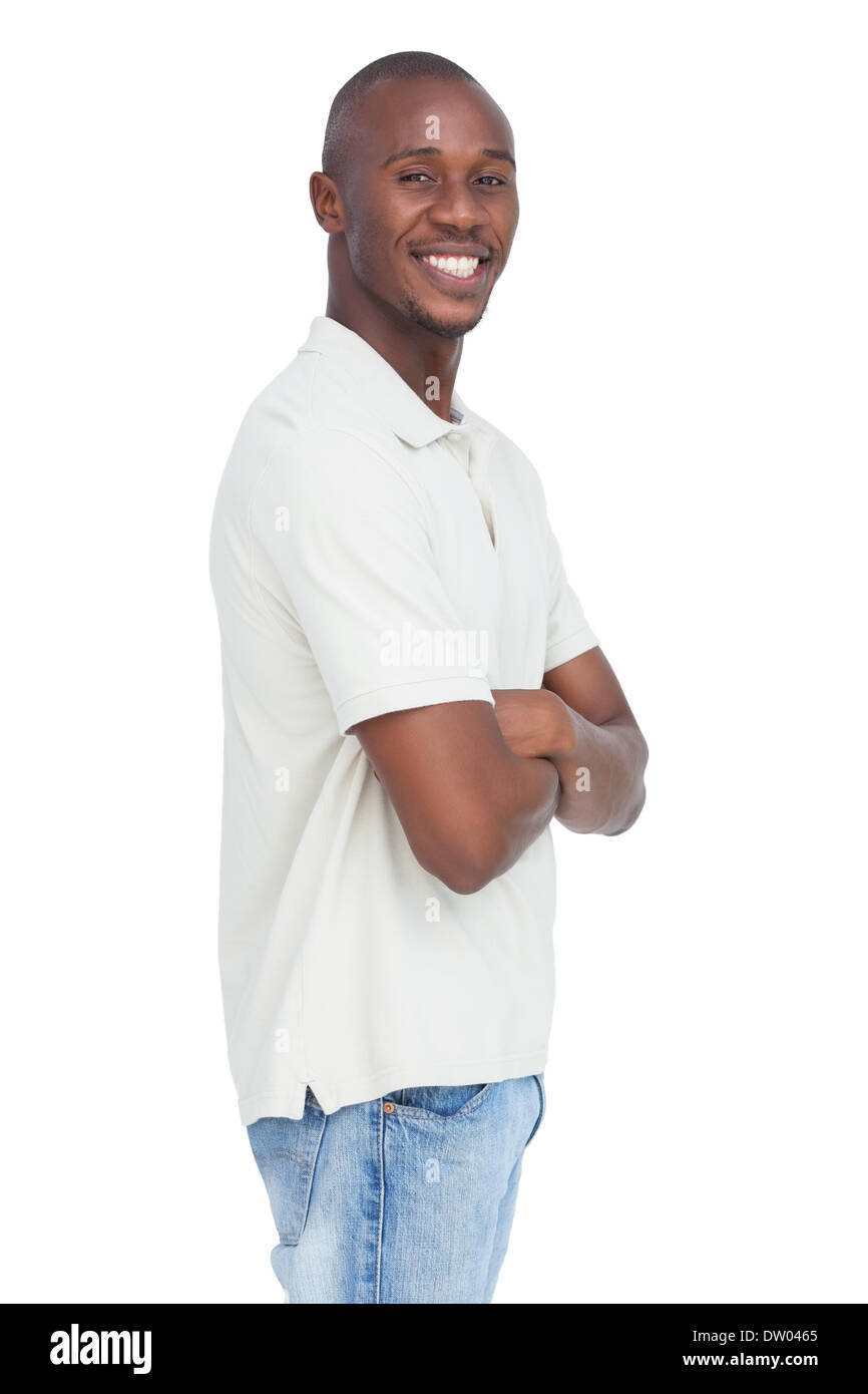 Smiling young man standing with arms crossed Stock Photo Alamy
