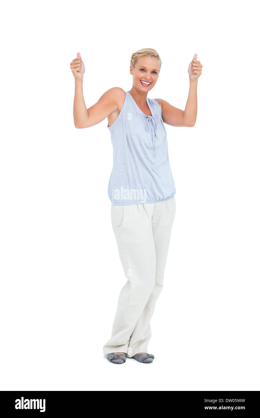 Blonde woman standing with thumbs up Stock Photo - Alamy