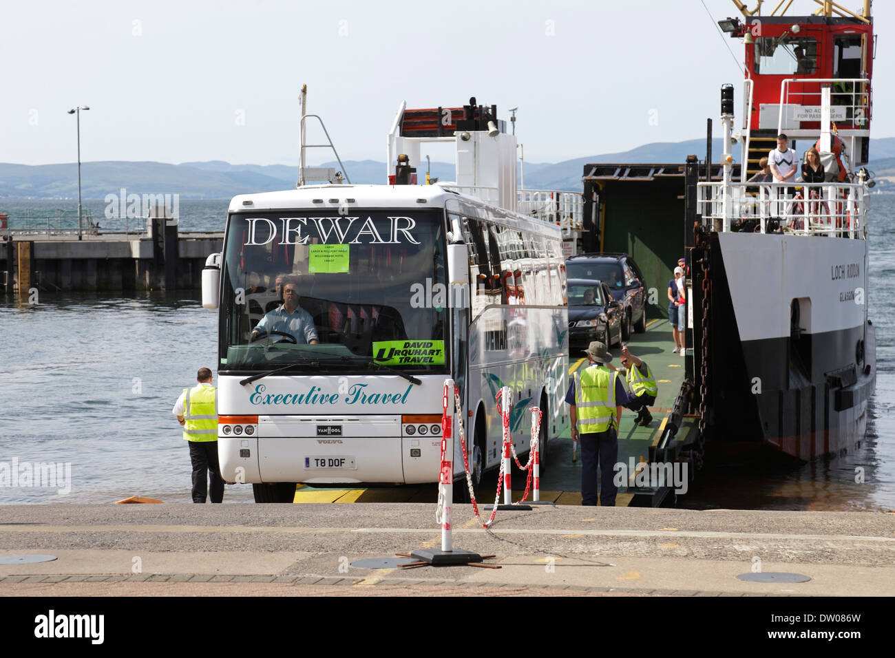 Tour bus driving off a Calmac ferry after sailing from the Island of Great Cumbrae, Largs Harbour, Firth of Clyde, Scotland, UK Stock Photo