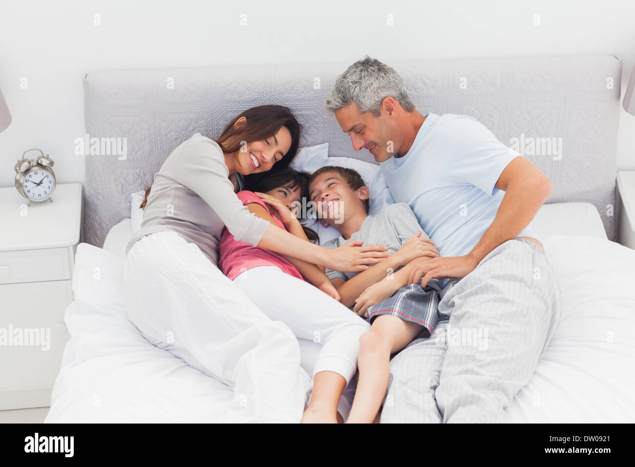 Happy family lying on bed hi-res stock photography and images - Alamy