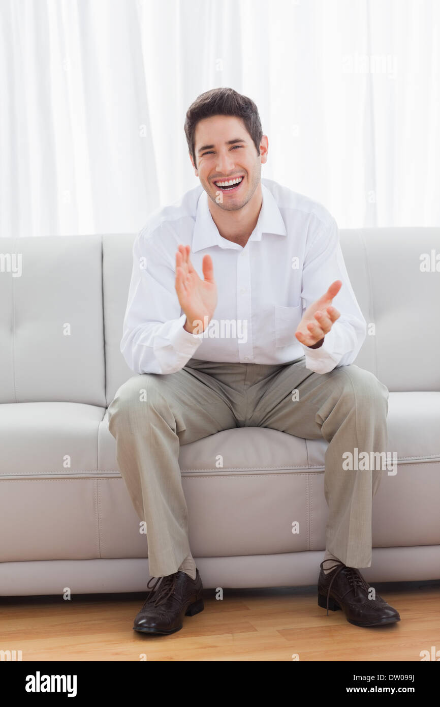 Man sitting on sofa cheering hi-res stock photography and images - Alamy