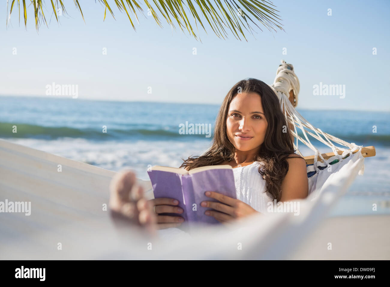 Peaceful woman lying on hammock reading book Stock Photo - Alamy