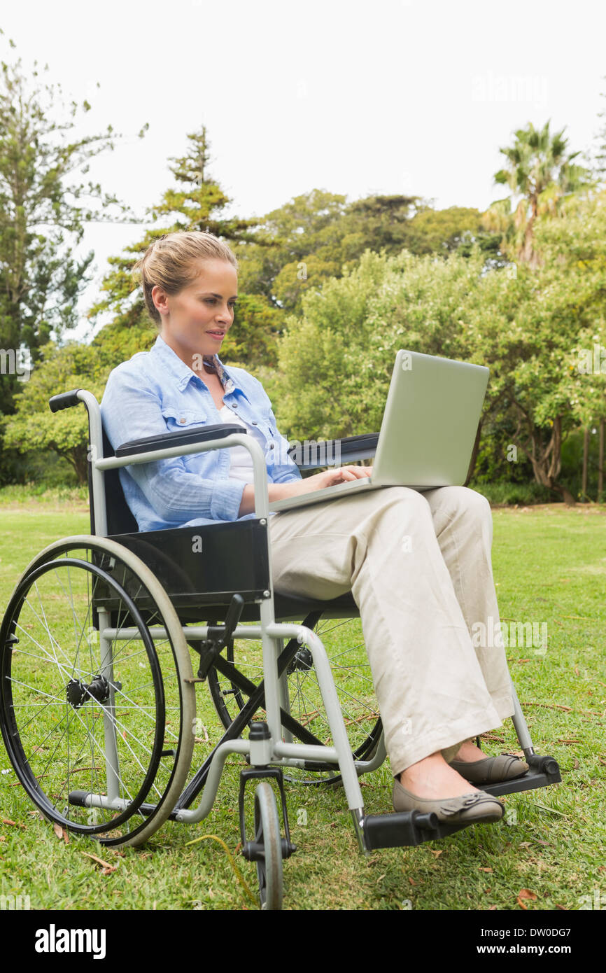 Happy woman in a wheelchair using a laptop Stock Photo - Alamy