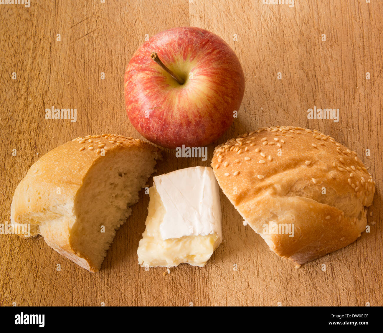 Apple, bread and cheese on a timber surface. Stock Photo