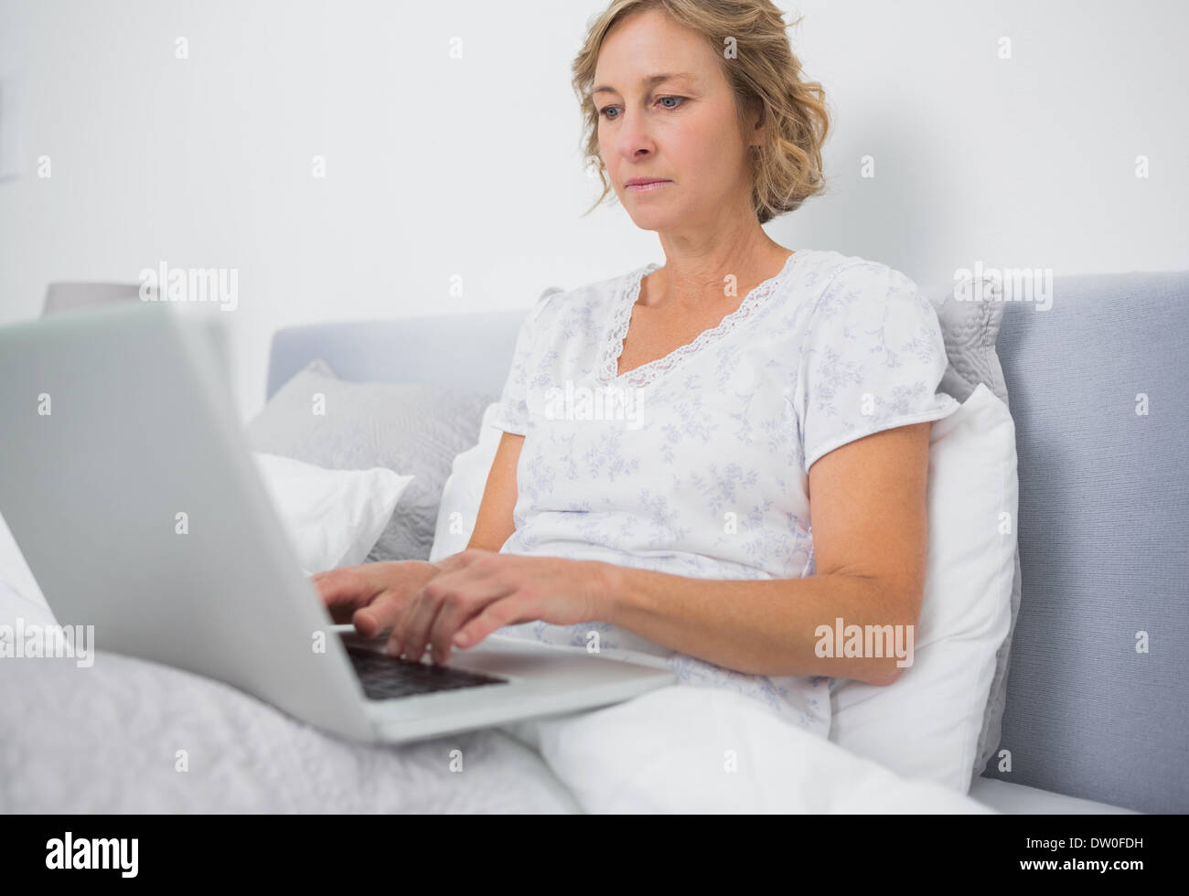 Blonde mature woman typing hi-res stock photography and images - Alamy