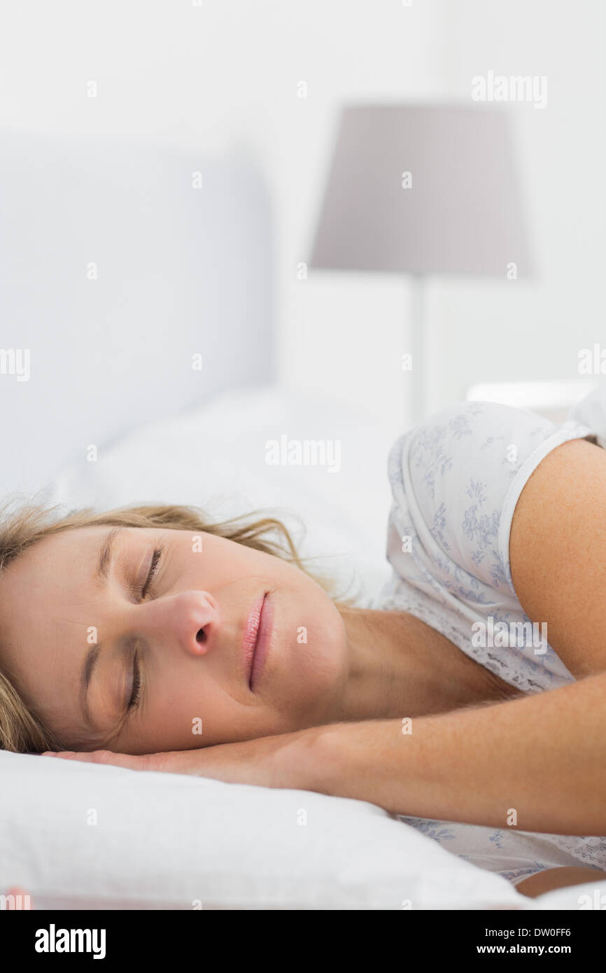 Blonde woman sleeping in bed Stock Photo