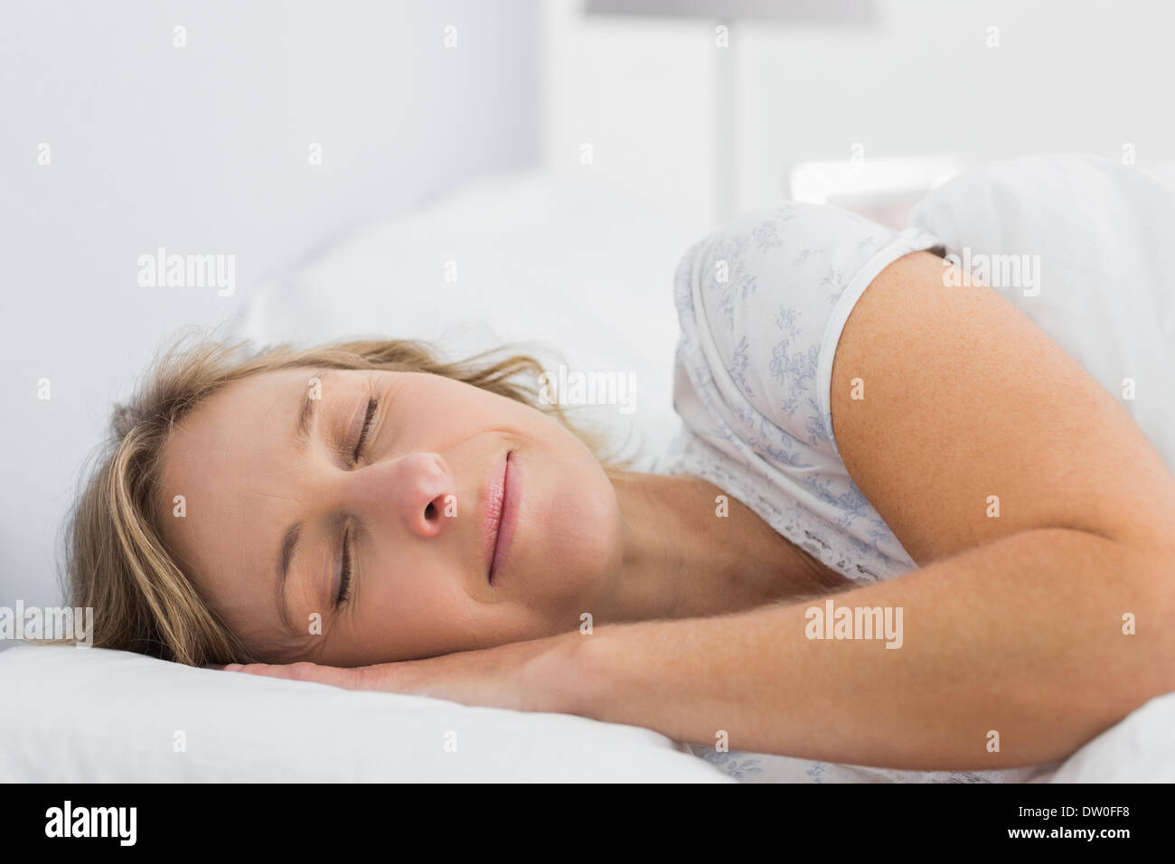 Peaceful blonde woman sleeping in bed Stock Photo