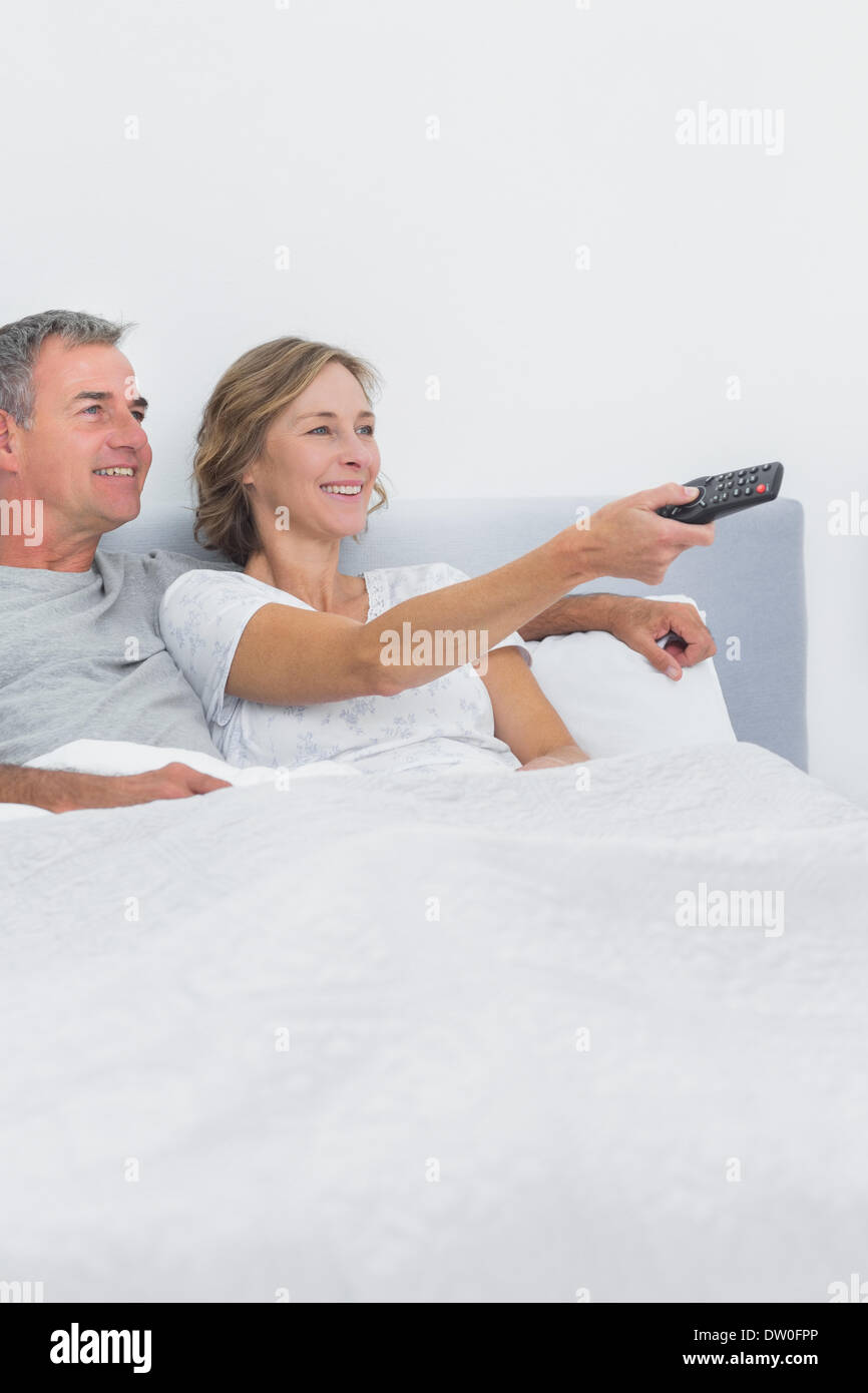 Relaxed couple watching tv in bed Stock Photo Alamy