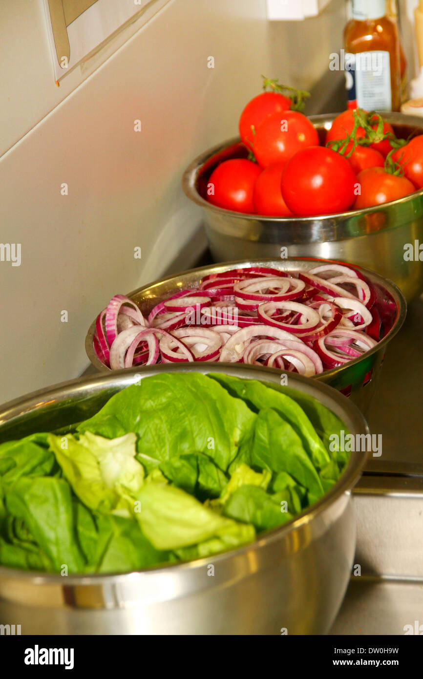 Chopped salad and vegetables on food prep area Stock Photo