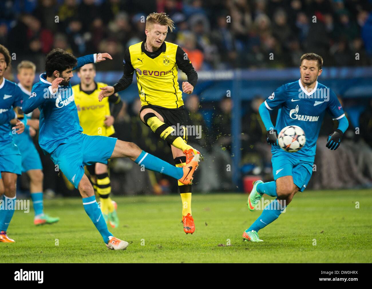 St. Peterburg, Russia. 25th Feb, 2014. Dortmund's Marco Reus (C) vies for the Ball with Zenit's Luis Neto and Viktor Fayzulin (R) during the UEFA Champions League round of 16 first leg soccer match between Zenit St. Petersburg and Borussia Dortmund at Petrowski stadium in St. Peterburg, Russia, 25 February 2014. Photo: Bernd Thissen/dpa/Alamy Live News Stock Photo
