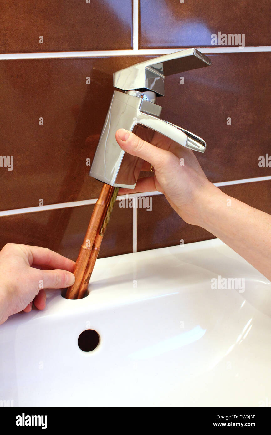 DIY plumber fitting a tap during a new bathroom renovation Stock Photo