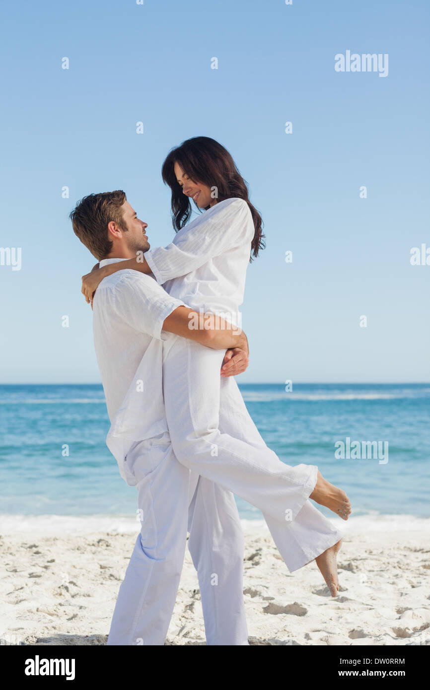 Happy man holding woman in arms Stock Photo Alamy