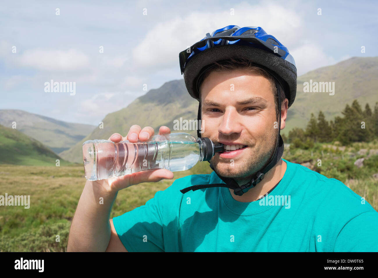 Fit man wearing bike helmet drinking water Stock Photo Alamy