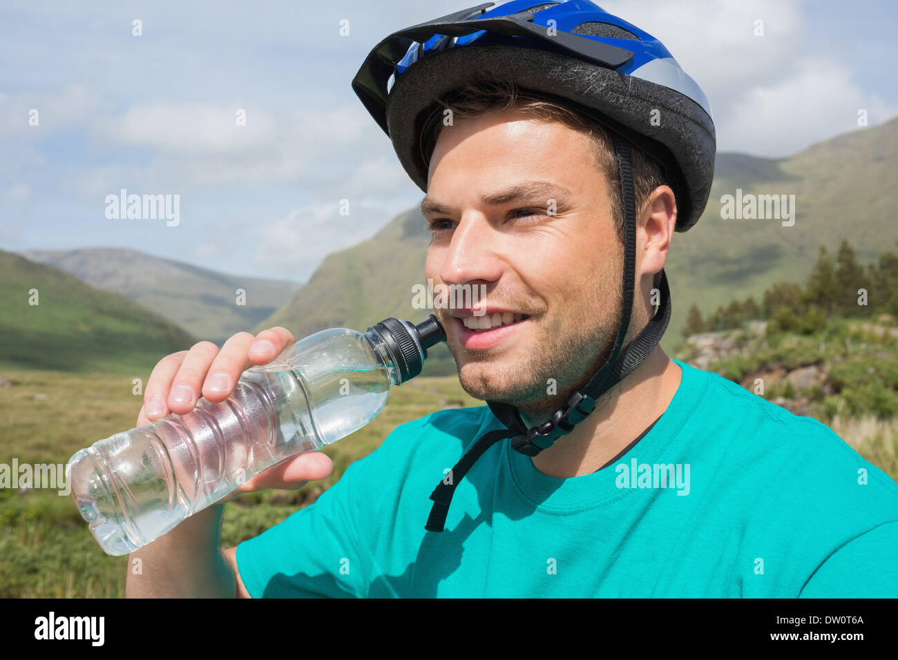 Fit man wearing helmet drinking water Stock Photo Alamy