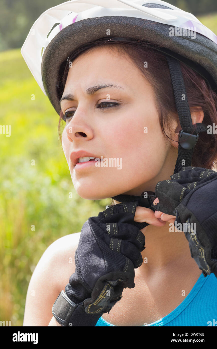Athletic woman adjusting her bike helmet Stock Photo - Alamy