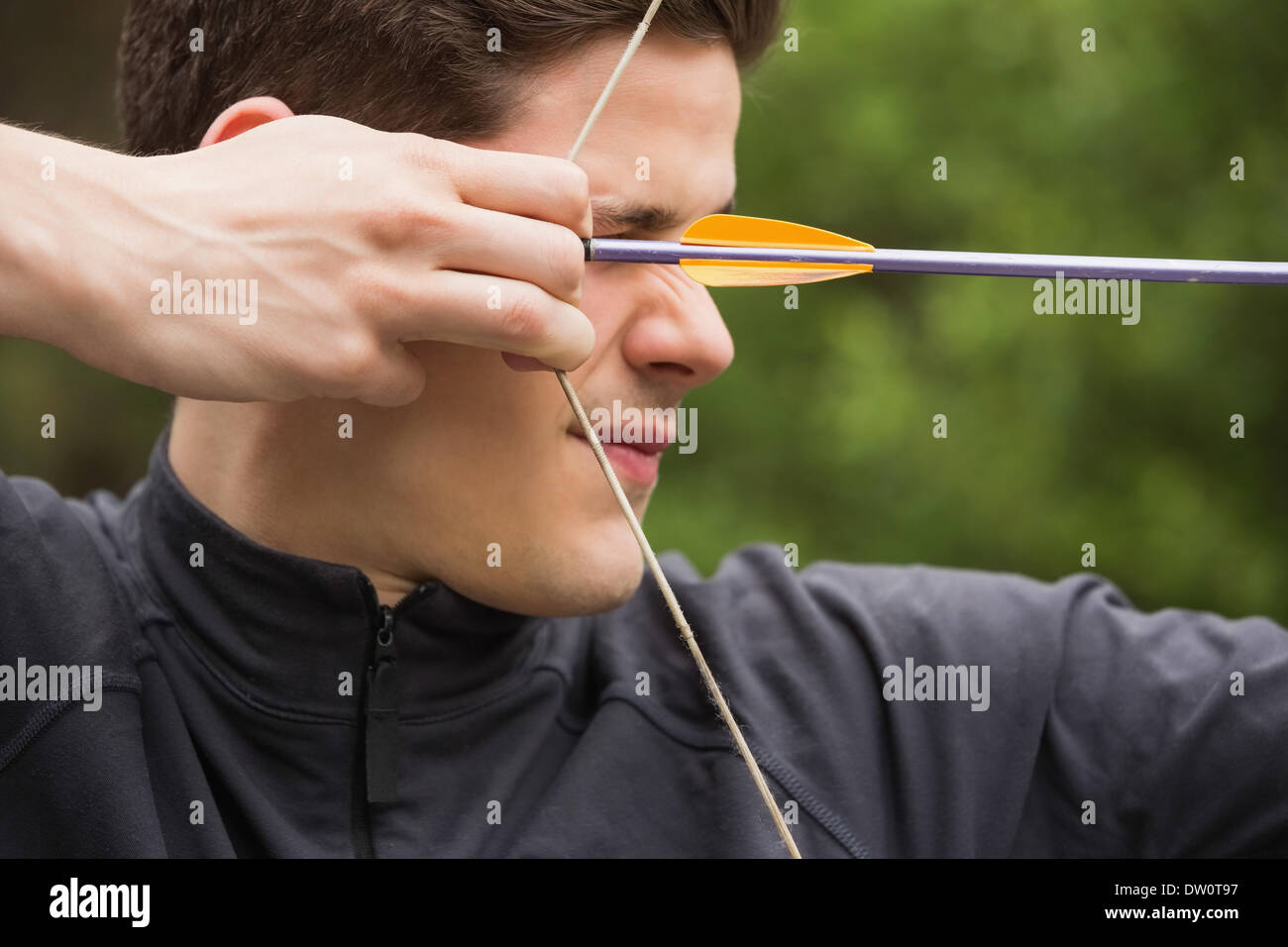 Concentrated man practicing archery Stock Photo