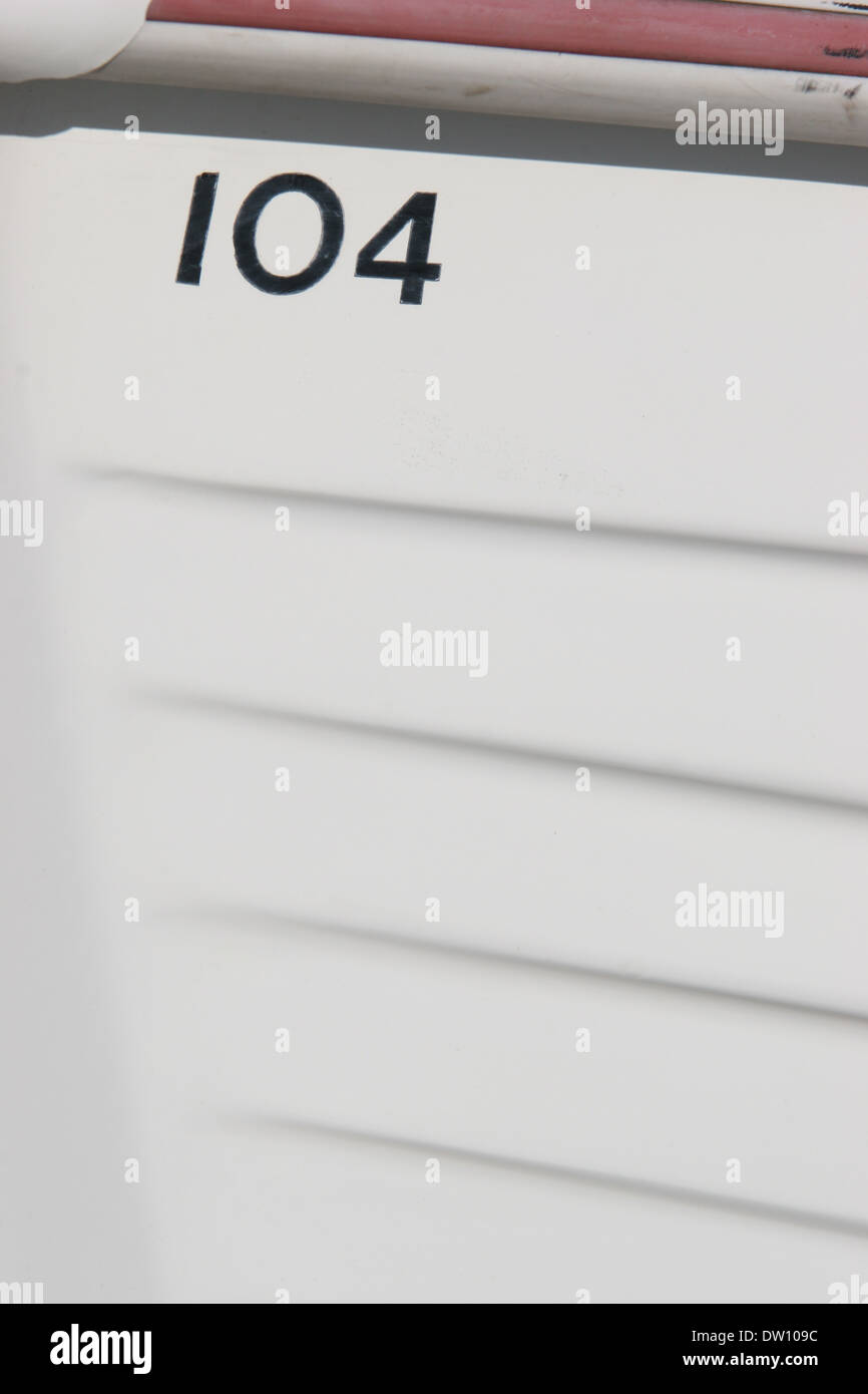 Number 104 on the hull of a white wooden boat Stock Photo