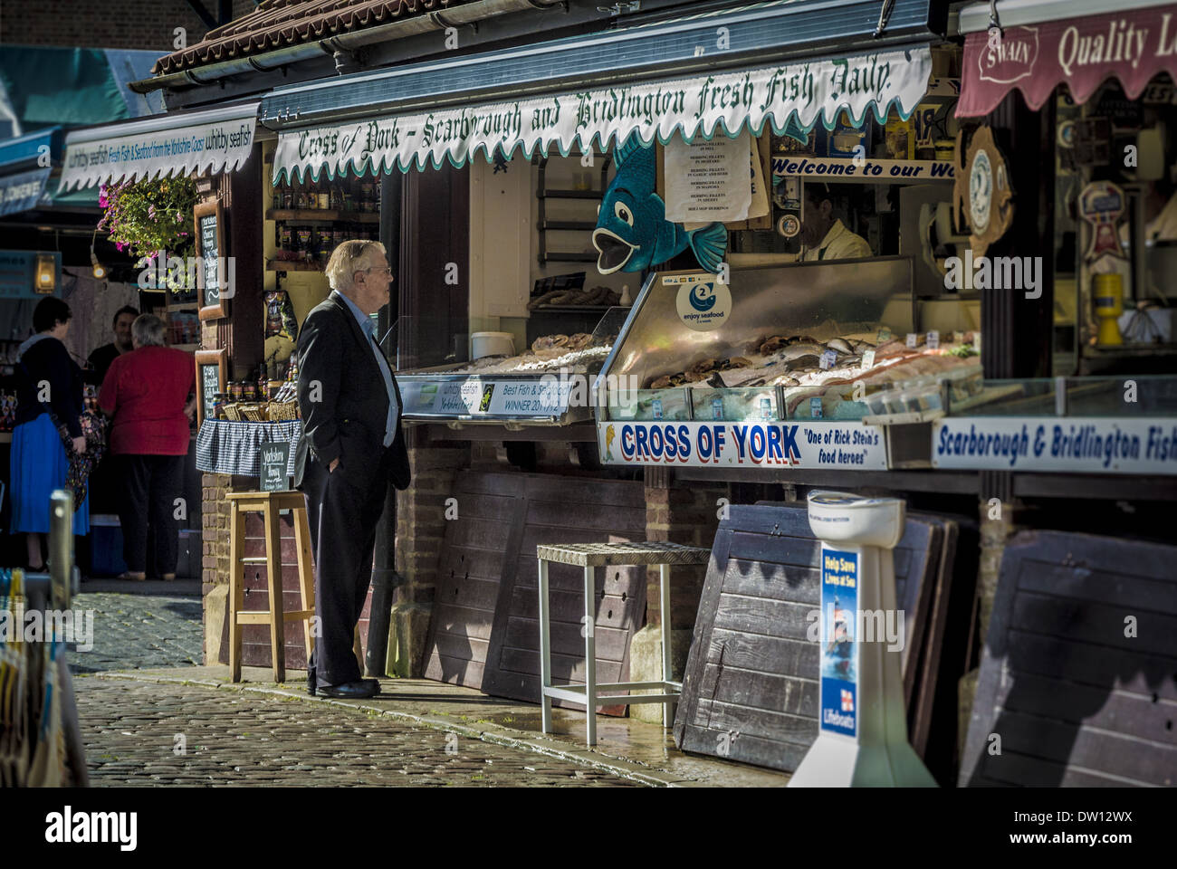 Man at fishmongers stall in York Market, UK. Stock Photo