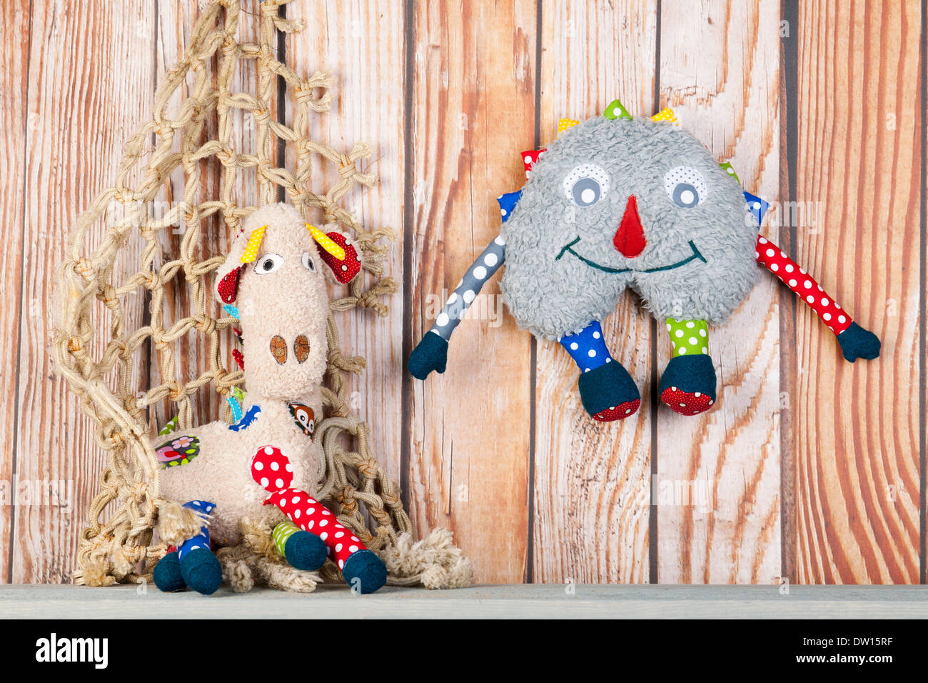 Stuffed colorful handmade funny toys at home on wooden background Stock Photo