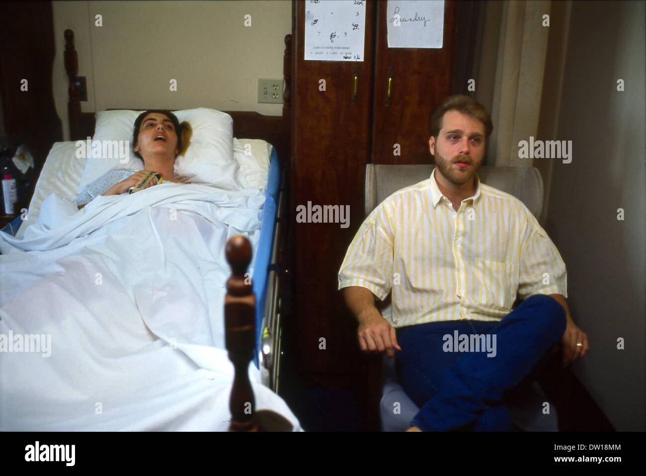 Nov 7, 1990 - St Petersburg, Florida, U.S. - MIKE SCHIAVO visits with his wife TERRI SCHIAVO, a coma victim at College Harbor Nursing Home. Terri Schiavo collapsed in her St. Petersburg, Florida, home in full cardiac arrest on February 25, 1990. She suffered massive brain damage due to lack of oxygen and, after two and a half months in a coma, her diagnosis was changed to vegetative state. In 1998 Schiavo's husband, Michael, petitioned the Sixth Circuit Court of Florida (Pinellas County), to remove her feeding tube pursuant to Florida Statutes Section 765.401(3). He was opposed by Terri's pare Stock Photo
