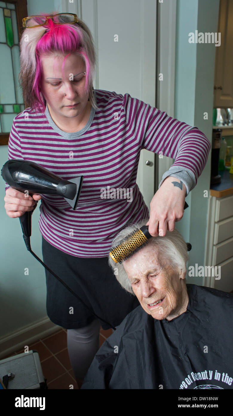 Detroit, Michigan - Hair stylist Jessica Willson, 36, gives a haircut to Dorothy Newell, 100. Stock Photo