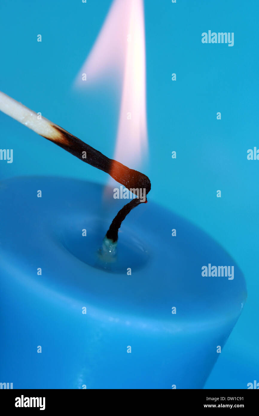 lighting of blue candle with match Stock Photo Alamy