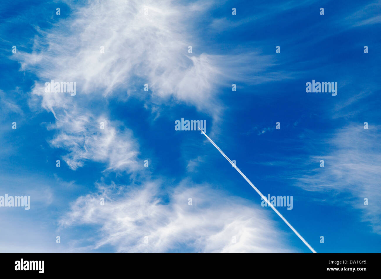 Jet contrails and wispy white clouds against a clear blue azure Colorado sky Stock Photo