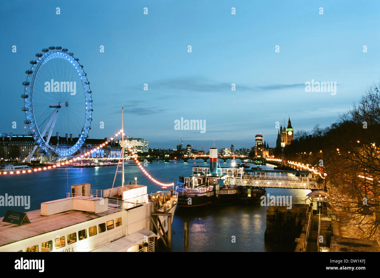 River Thames in winter with the London Eye and boats at dusk, London UK Stock Photo