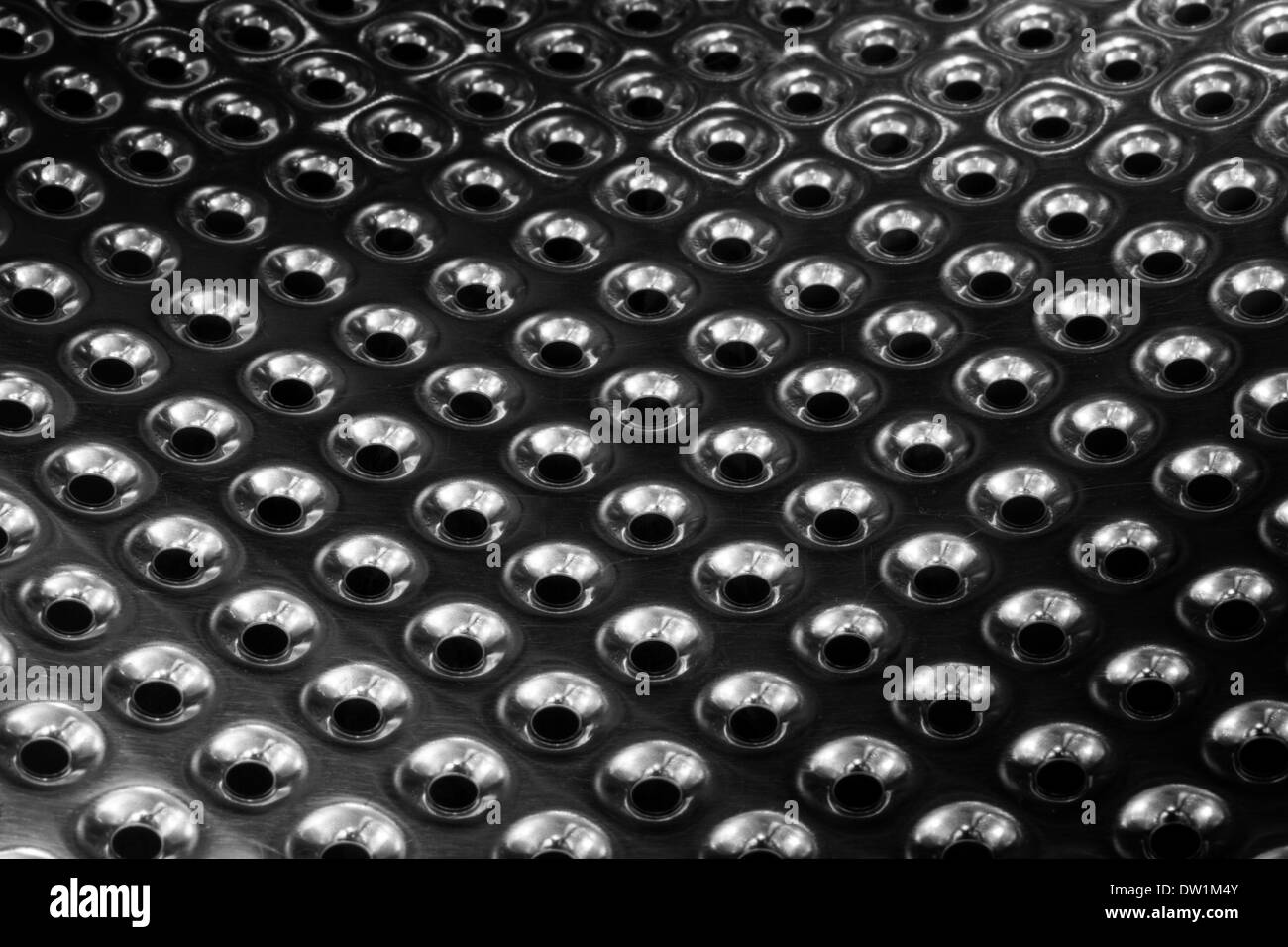 concave metal surface background with holes Stock Photo