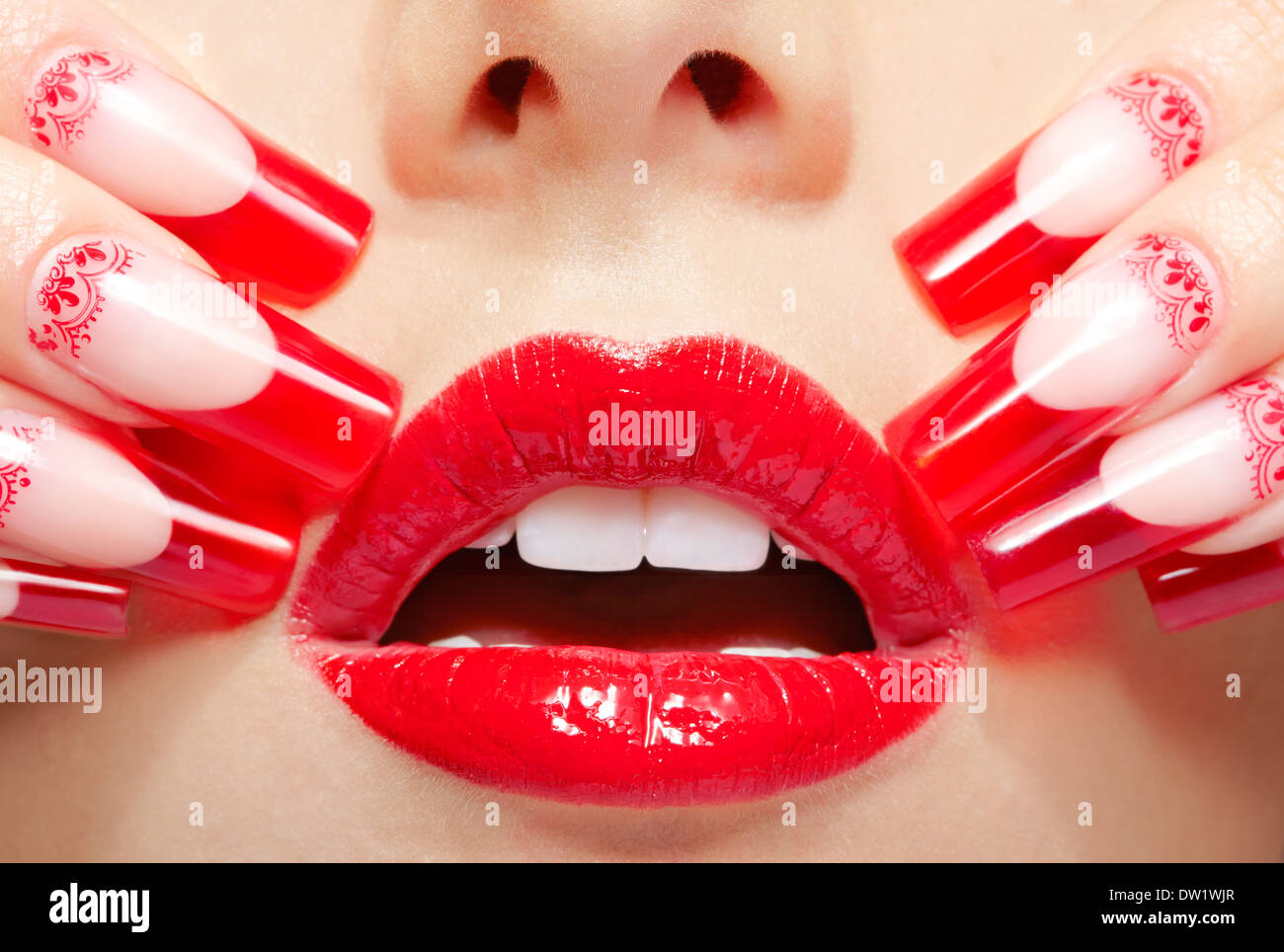 Fingers with red french acrylic nails manicure and paiting Stock Photo