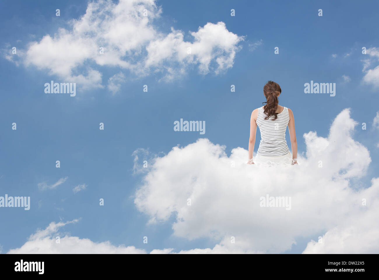 Brunet woman sit on clouds Stock Photo