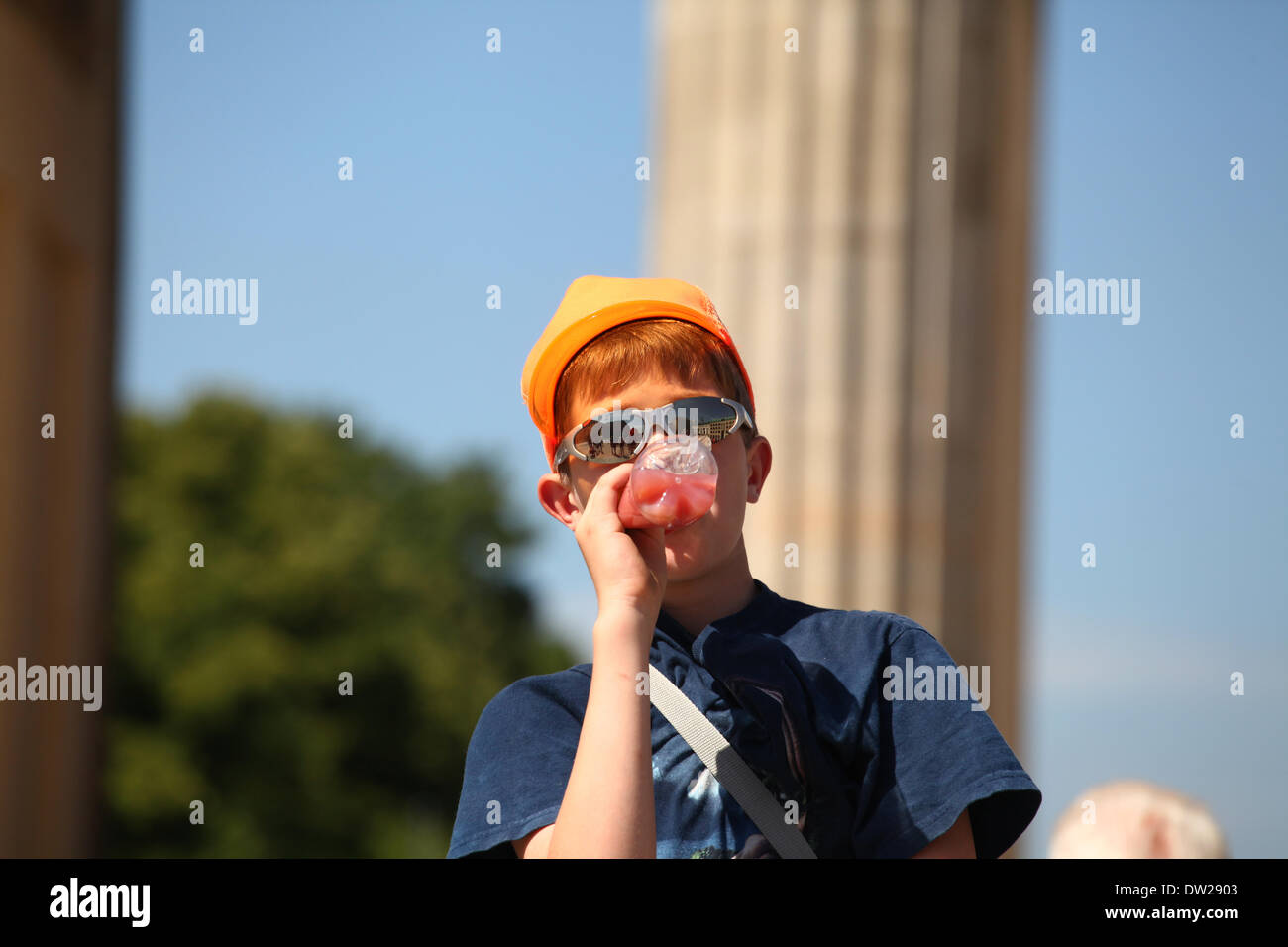 A young man drinking from a bottle at the Brandenburg Gate in Berlin, July 16, 2013. More and more tourists come to the German capital every year. This photo is part of a series on tourism in Berlin. Photo: Wolfram Steinberg dpa Stock Photo