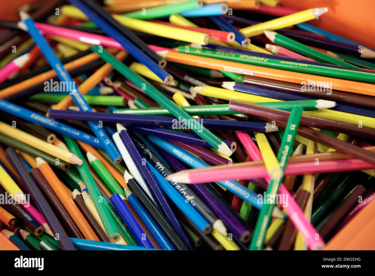 A pile of coloured colored pencils in a school classroom Stock Photo