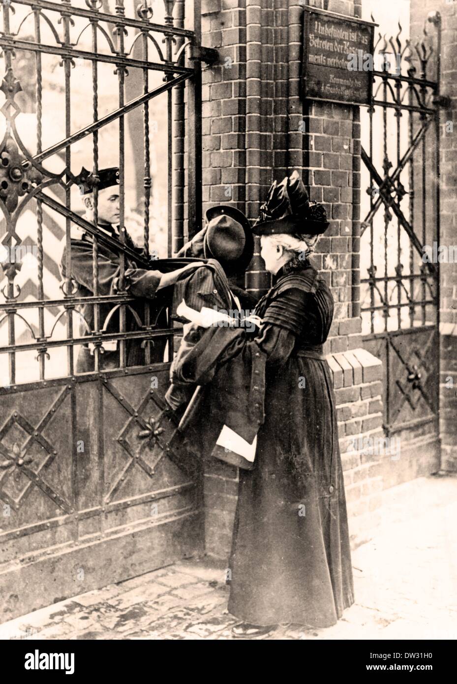 A young man wearing a new uniform hands his mother his civilian clothing through the barrack gate in Berlin, Germany, 1914. Fotoarchiv für Zeitgeschichte - NO WIRE SERVICE Stock Photo