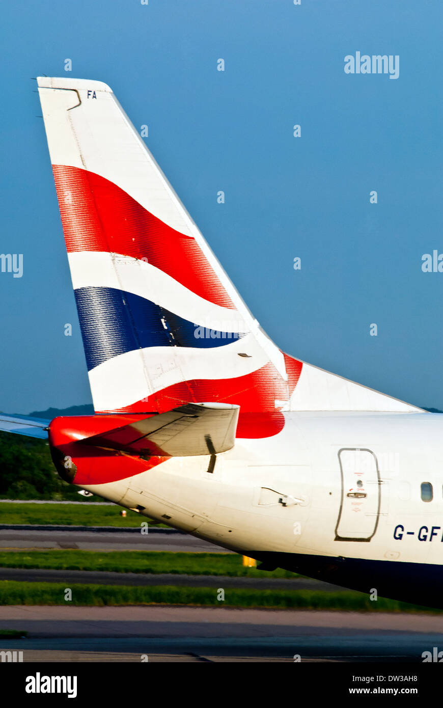 The tail fin of a British Airways jet taxiing at Manchester Airport, UK Stock Photo